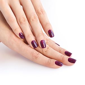 Manos cuidadas y uñas maquilladas en color berenjena.